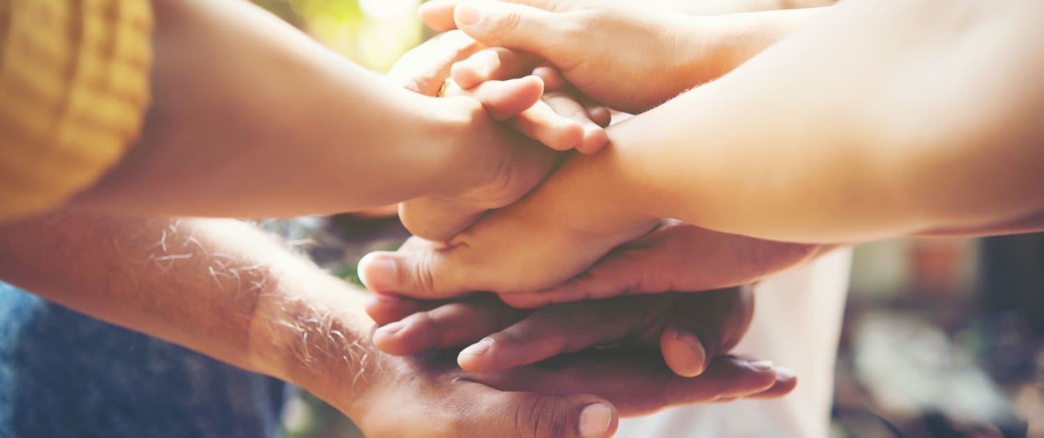 Close up of young people putting their hands together. Team with